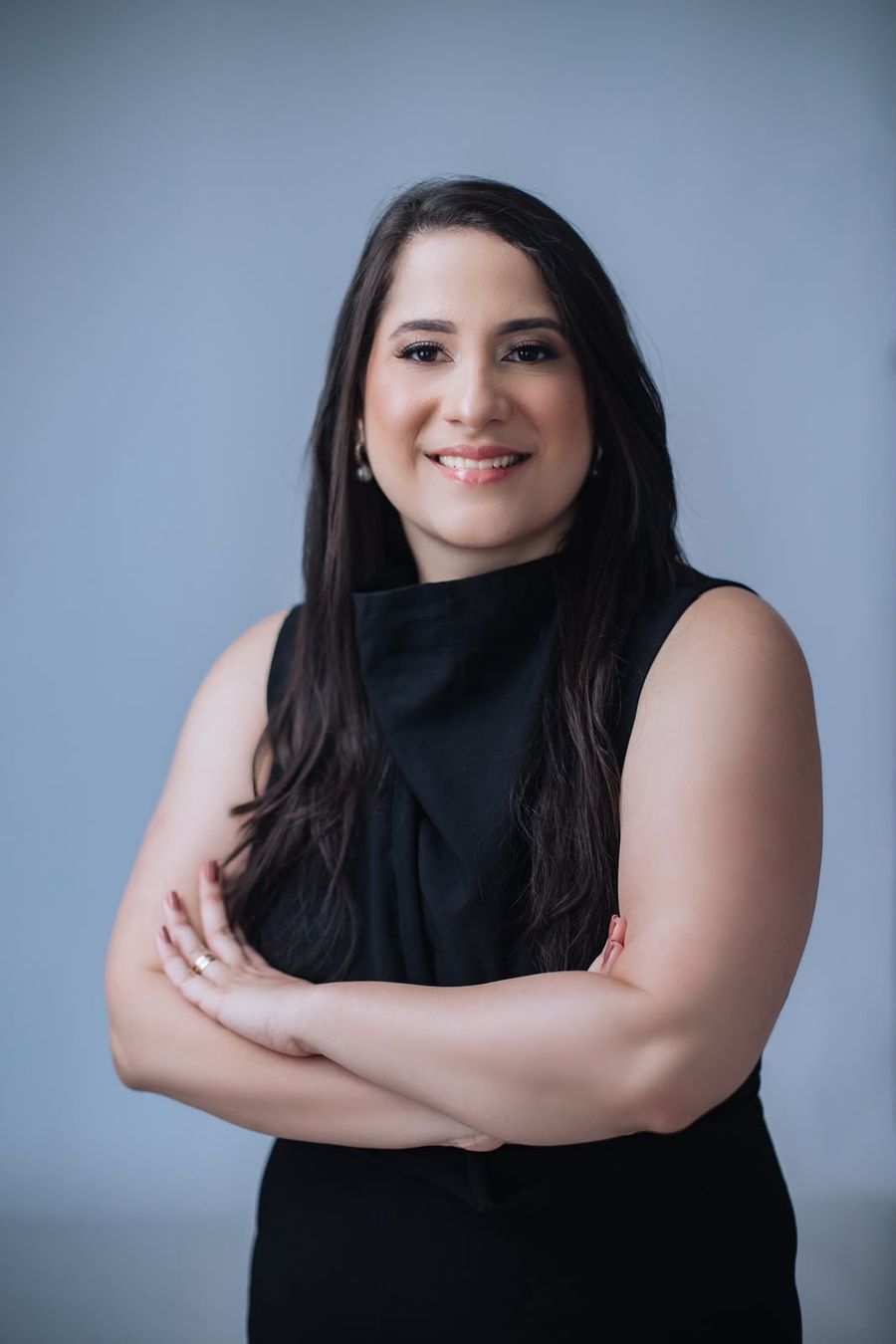 Dra. Renata Ramos, ginecologista e obstetra, sorrindo com os braços cruzados